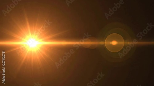 A bright golden light flare shines across a dark background