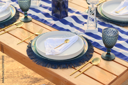 Nautical themed outdoor dining table setting for summer celebration