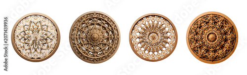 A circular, intricately carved wooden mandala is presented against a stark transparent background.