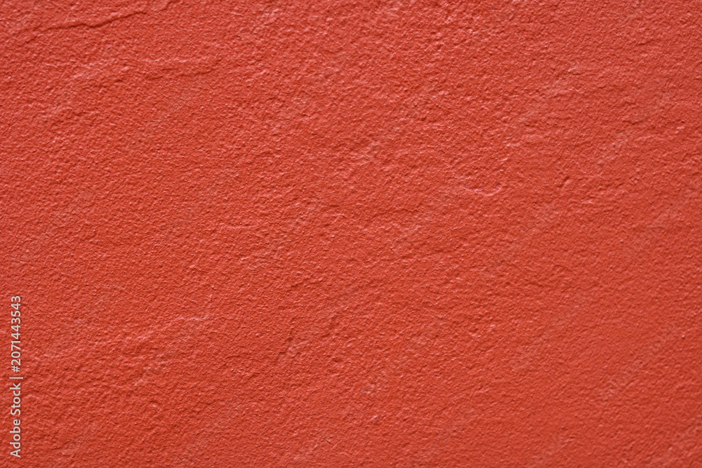 Fototapeta premium A solid painted stucco or plaster wall surface. A clean slate with a bright red hue to create a minimalist, industrial abstract background.