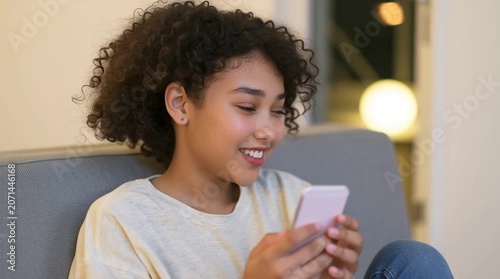 Curly light Brown teen in puberty period is chatting on the dating app. Generation Z is very active on social media