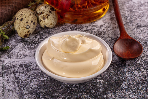 Photography Creamy mayonnaise in bowl with quail eggs, herbs and wooden spoon