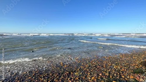 Panoramic view from a rocky beach of an island with palm trees.
