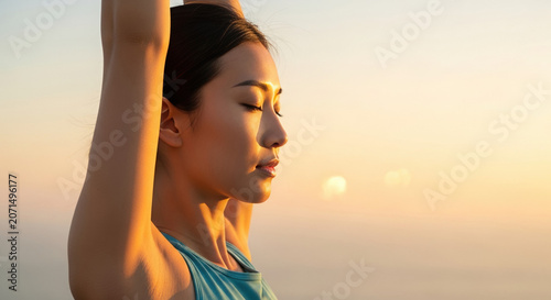 Asian woman practicing yoga at sunrise with closed eyes  