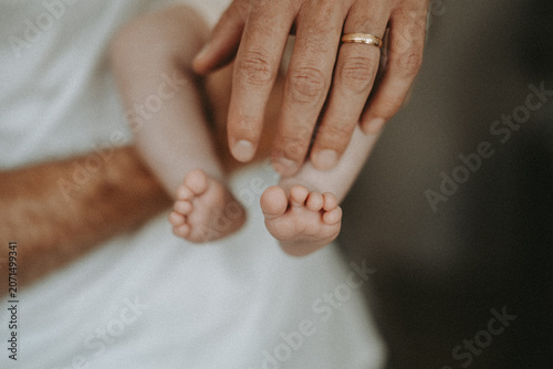 Canvas Print Petits pieds de nouveau-né dans les mains d’un parent