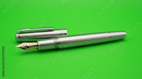 Pen in silver fountain style open on green
