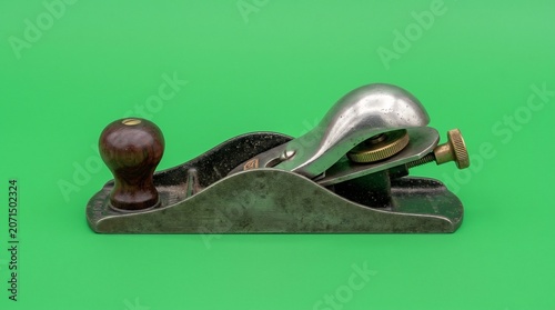 Vintage metal wood plane hand tool on green background