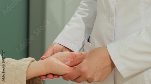 Doctor gently holds woman patient hand during supportive ward check. Medical specialist steadies fingers comforting woman through touch