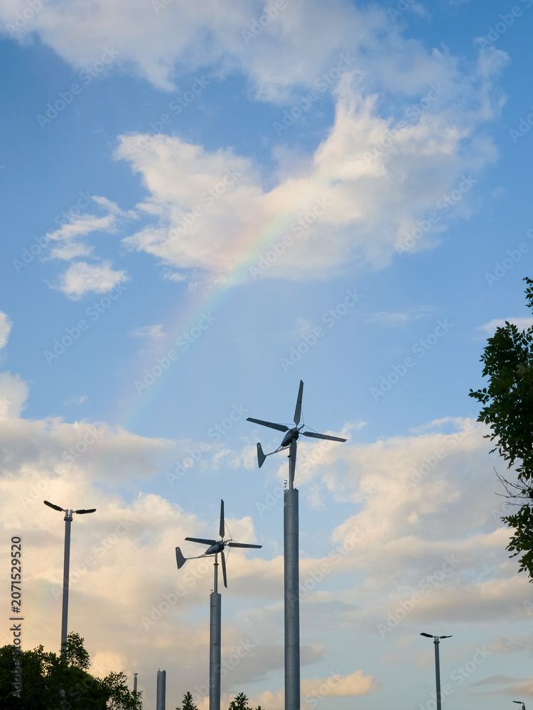 Naklejka premium Two small residential wind turbines stand tall against a vivid sky