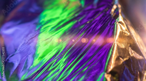 Abstract holographic iridescent texture of crumpled foil.