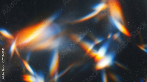 Abstract colorful bokeh light leaks on dark background.