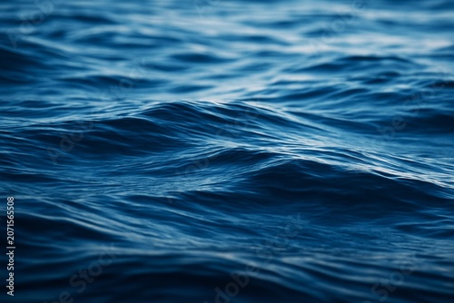 Close-up view of deep blue ocean waves with soft natural lighting and smooth textures, ideal for creative backgrounds and tranquil atmospheres. Ai generative