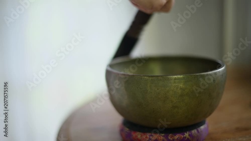 Woman holding Tibetan singing bowl during meditation