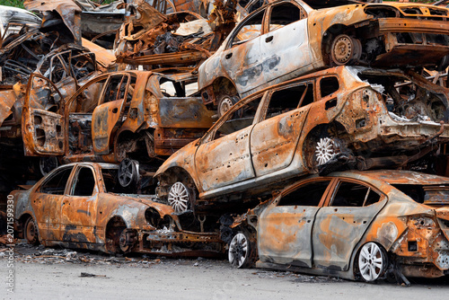 Schilderij op canvas Cars stacked in a junkyard during daylight showing rust and wear from years of n
