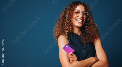 Money and credit themes surround the woman in a blue studio card portrait
