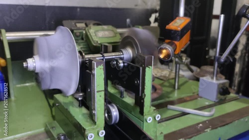 A professional industrial dynamic balancing machine testing and calibrating a spinning turbocharger shaft wheel assembly in a workshop shop environment.