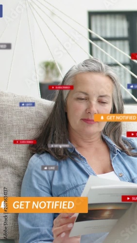 Vertical video: Woman reading book seeing alert banner social badges animating around her fading