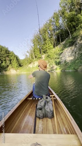 Rear view of man fishing from canoe