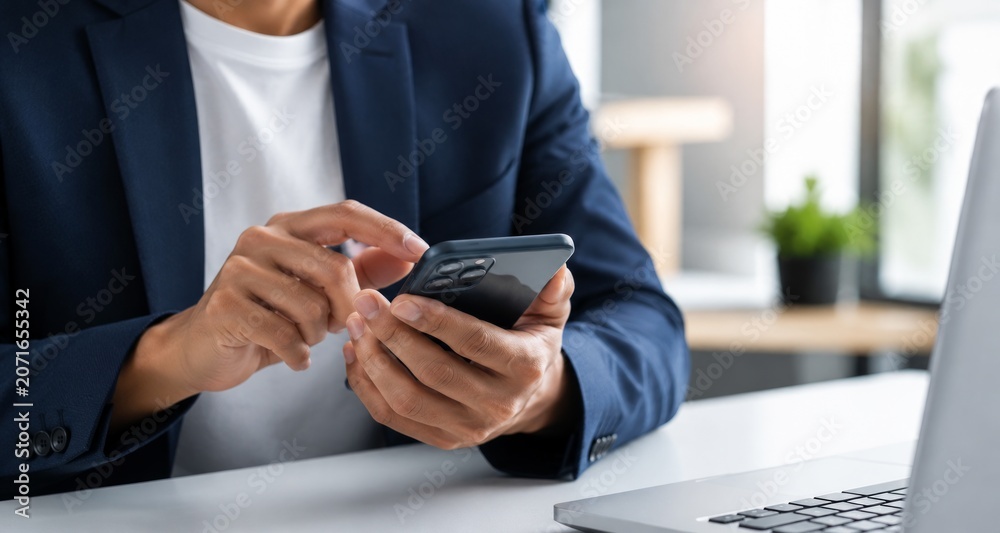 Fototapeta premium Professional Asian Woman Managing Business Tasks With Smartphone At Desk