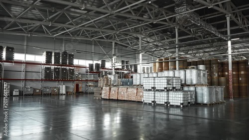 Industrial Warehouse Scene. Logistics Manager Reviews Inventory Amidst Reflective Concrete Floor Environment