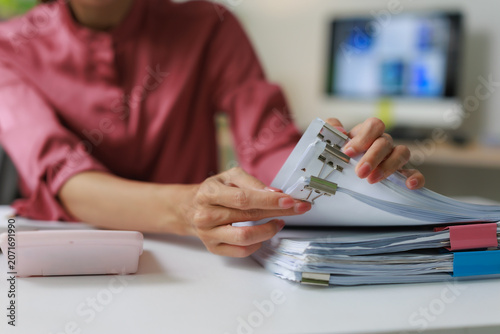 Fotografía Professional woman organizing office documents with binder clips, managing paper