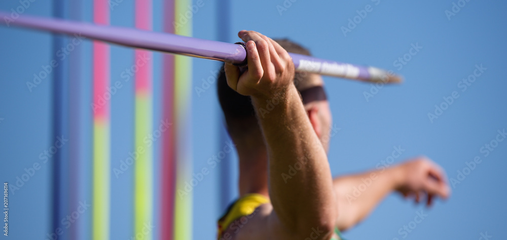 Obraz premium An athlete throwing a javelin in a sporting event, in the background a rack of javelins