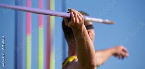 Foto An athlete throwing a javelin in a sporting event, in the background a rack of j