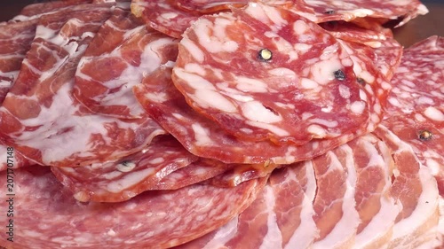 meat platter rotating with assortment of various spanish, french or italian appetizers - sliced prosciutto, parma sausage, ham, boiled pork, salami, close up