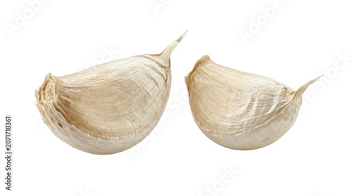 Two fresh garlic cloves with papery skin on white.