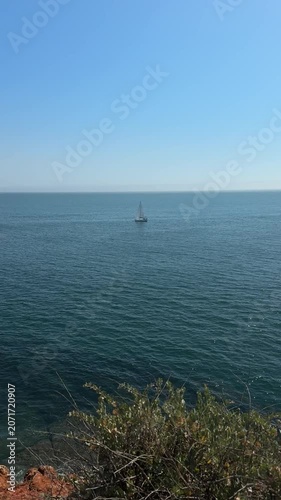 Lone sailboat sailing on a calm blue sea