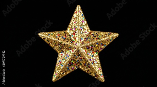 Golden glittering star Christmas ornament isolated on a black background