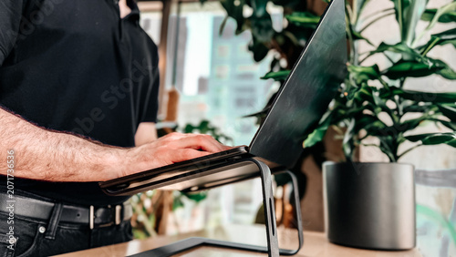 Photos Minimal office desk with ergonomic aluminum laptop stand near large window