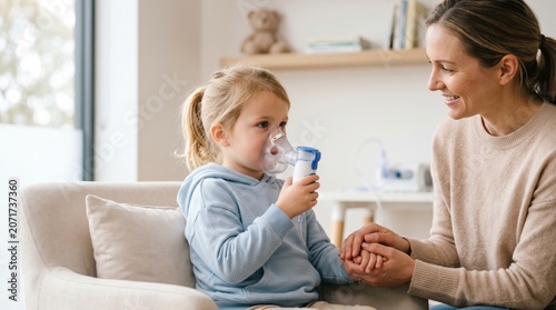 Mother helping child use nebulizer mask at home. Girl with asthma receiving medical respiratory treatment. Parent caring for sick kid during inhalation therapy. Healthcare at home.