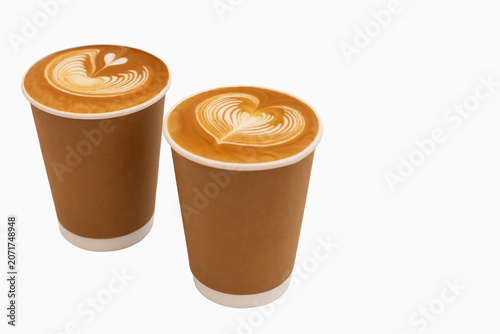 Coffee. Two disposable coffee cups filled with latte art showcasing heart designs on surface, positioned closely together against clean white background with copy space, intricate patterns of foam