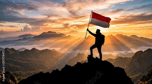 Hiker holding the Indonesian flag on a mountain summit at sunrise