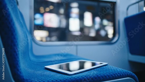 Tablet Left on Train Seat with City Lights Outside