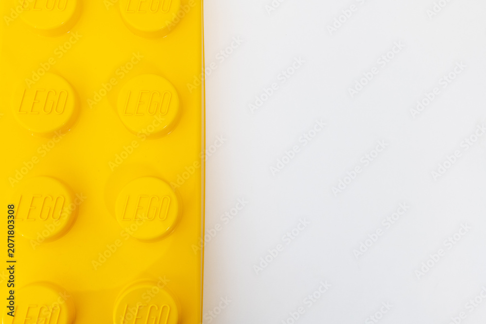 Naklejka premium Bradford, UK June 24 2026 - Close-up of a yellow LEGO storage container lid designed to resemble an ordinary LEGO brick, isolated on a white background with copy space.