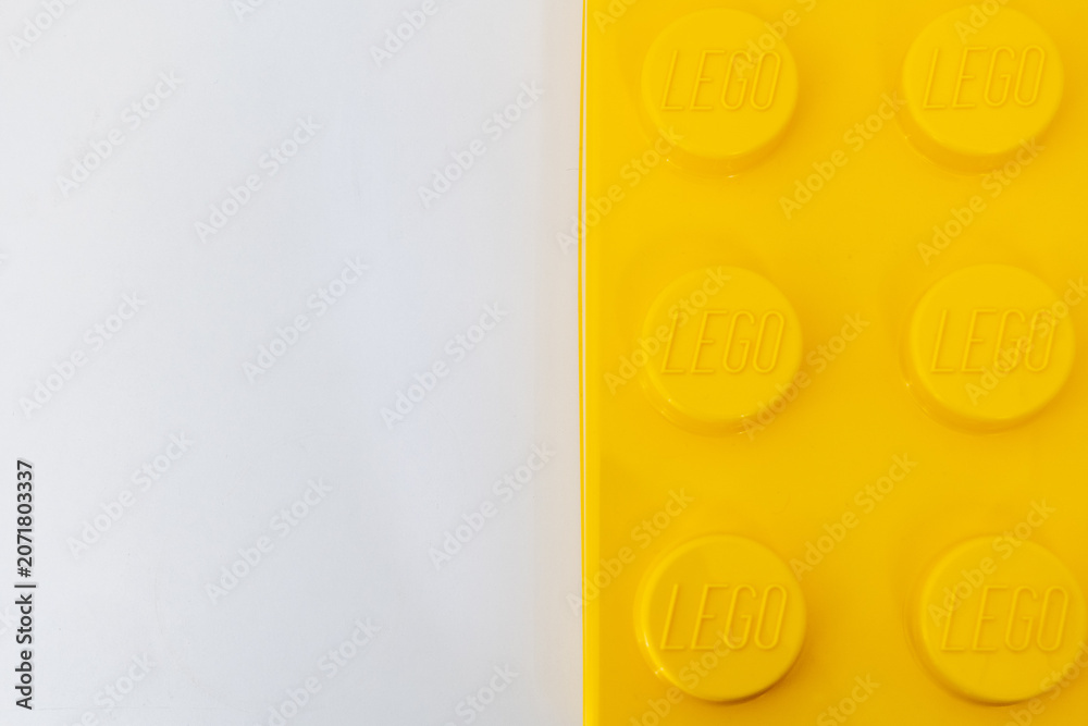 Naklejka premium Bradford, UK June 24 2026 - Close-up of a yellow LEGO storage container lid designed to resemble an ordinary LEGO brick, isolated on a white background with copy space.