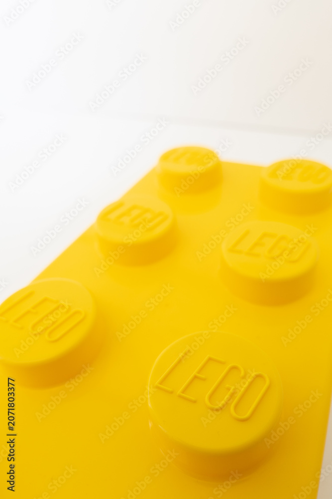 Naklejka premium Bradford, UK June 24 2026 - Close-up of a yellow LEGO storage container lid designed to resemble an ordinary LEGO brick, isolated on a white background with copy space.