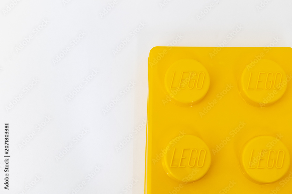 Naklejka premium Bradford, UK June 24 2026 - Close-up of a yellow LEGO storage container lid designed to resemble an ordinary LEGO brick, isolated on a white background with copy space.