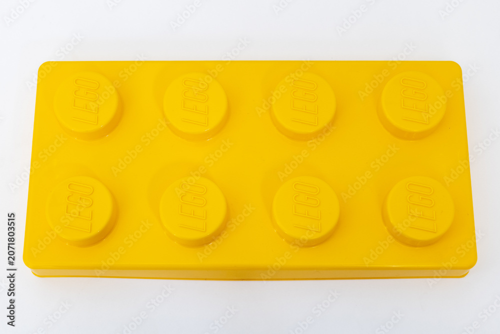Naklejka premium Bradford, UK June 24 2026 - Close-up of a yellow LEGO storage container lid designed to resemble an ordinary LEGO brick, isolated on a white background with copy space.