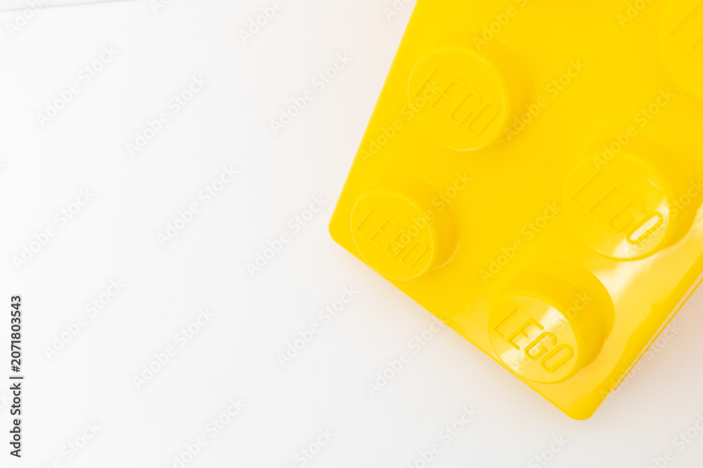 Naklejka premium Bradford, UK June 24 2026 - Close-up of a yellow LEGO storage container lid designed to resemble an ordinary LEGO brick, isolated on a white background with copy space.