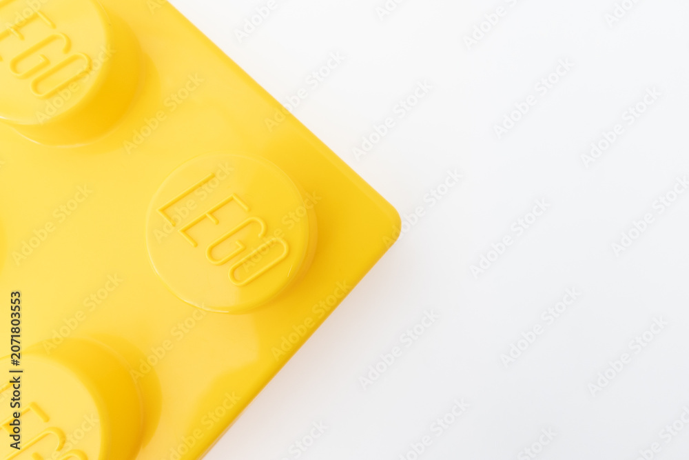Naklejka premium Bradford, UK June 24 2026 - Close-up of a yellow LEGO storage container lid designed to resemble an ordinary LEGO brick, isolated on a white background with copy space.