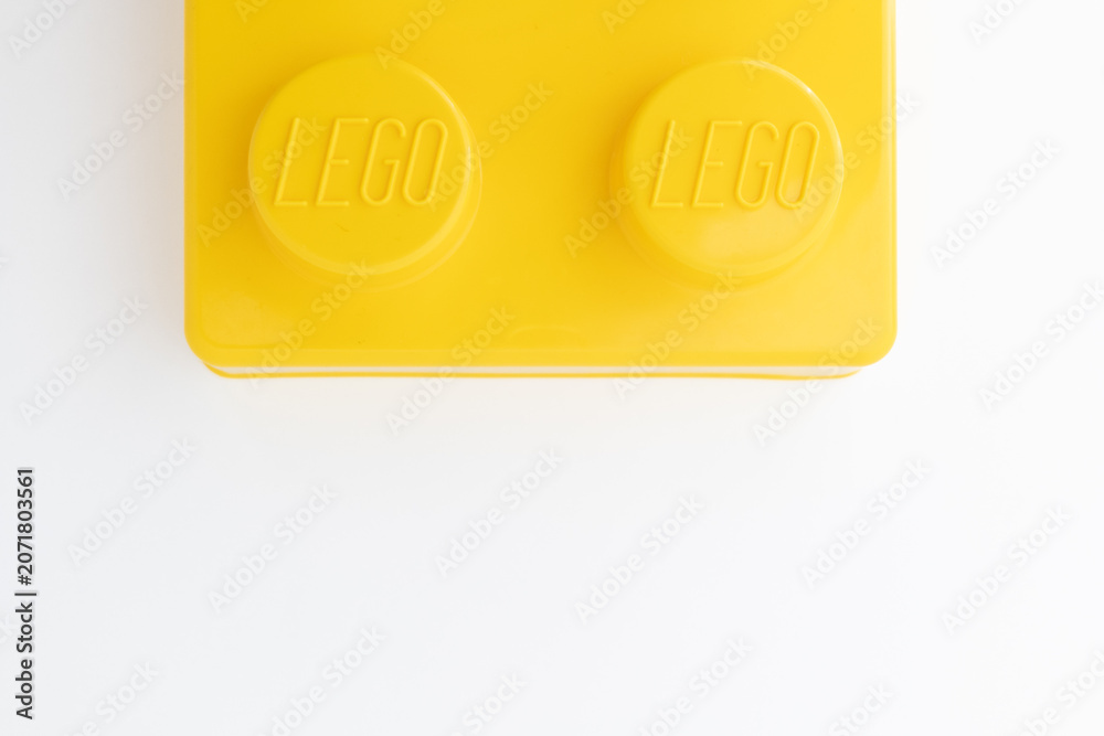 Naklejka premium Bradford, UK June 24 2026 - Close-up of a yellow LEGO storage container lid designed to resemble an ordinary LEGO brick, isolated on a white background with copy space.