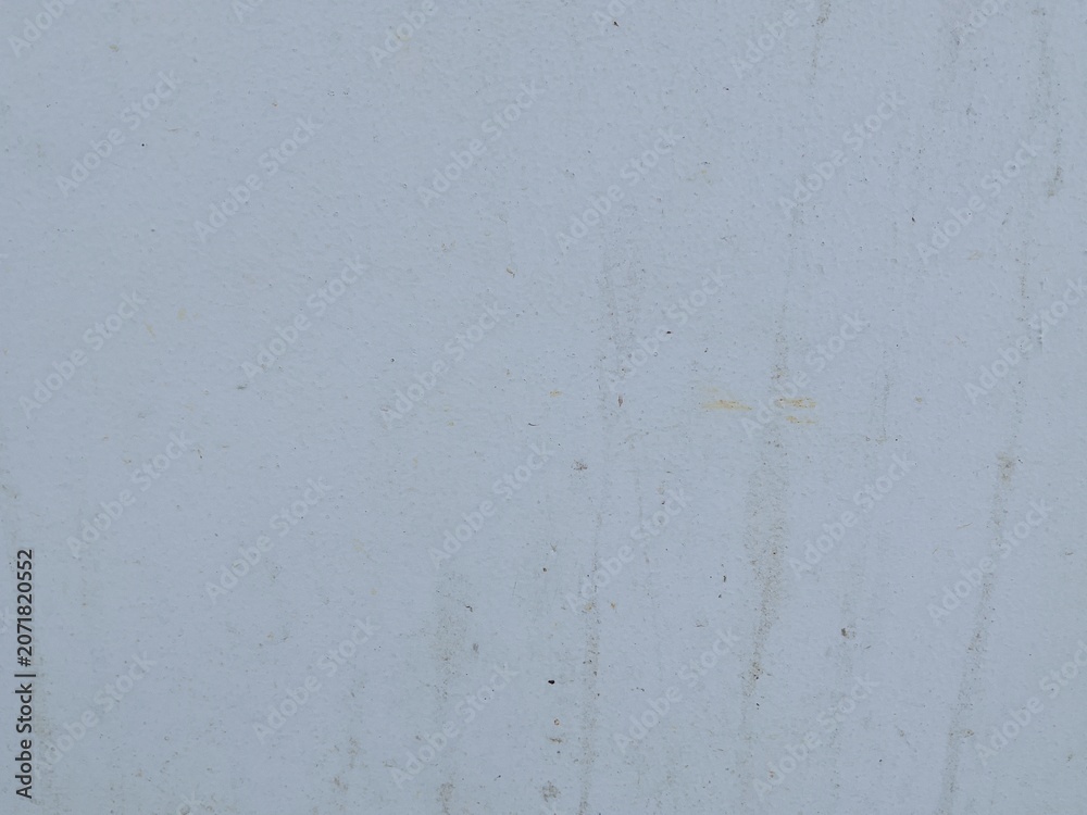 Fototapeta premium A weathered white wall texture featuring subtle dirt marks, stains, and natural surface imperfections. The minimalist background offers a neutral and versatile design element suitable for construction