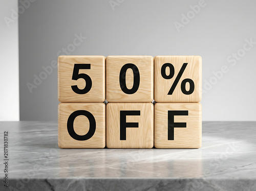 Wooden blocks stacked to form 50 percent off sale sign on marble surface