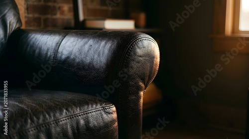 Dark brown leather armchair in a dimly lit room with warm sunlight