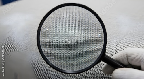 Magnifying glass examining mesh textile detail