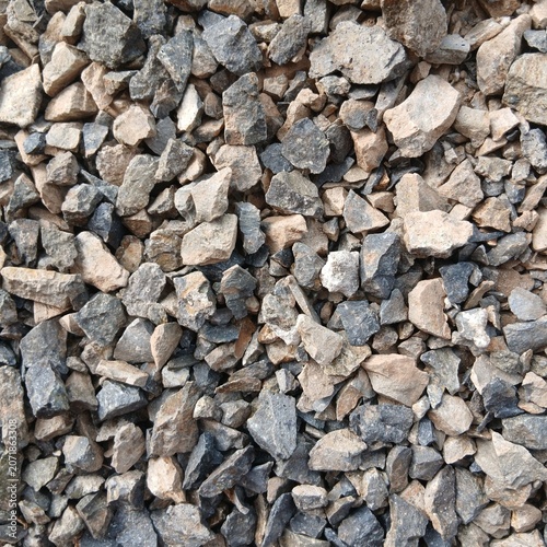 Top view of gray and brown crushed gravel stones forming a textured background