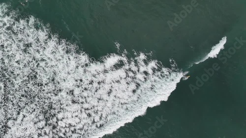 Aerial Drone Footage of Surfers Riding Waves on a Beach in Bali, Indonesia